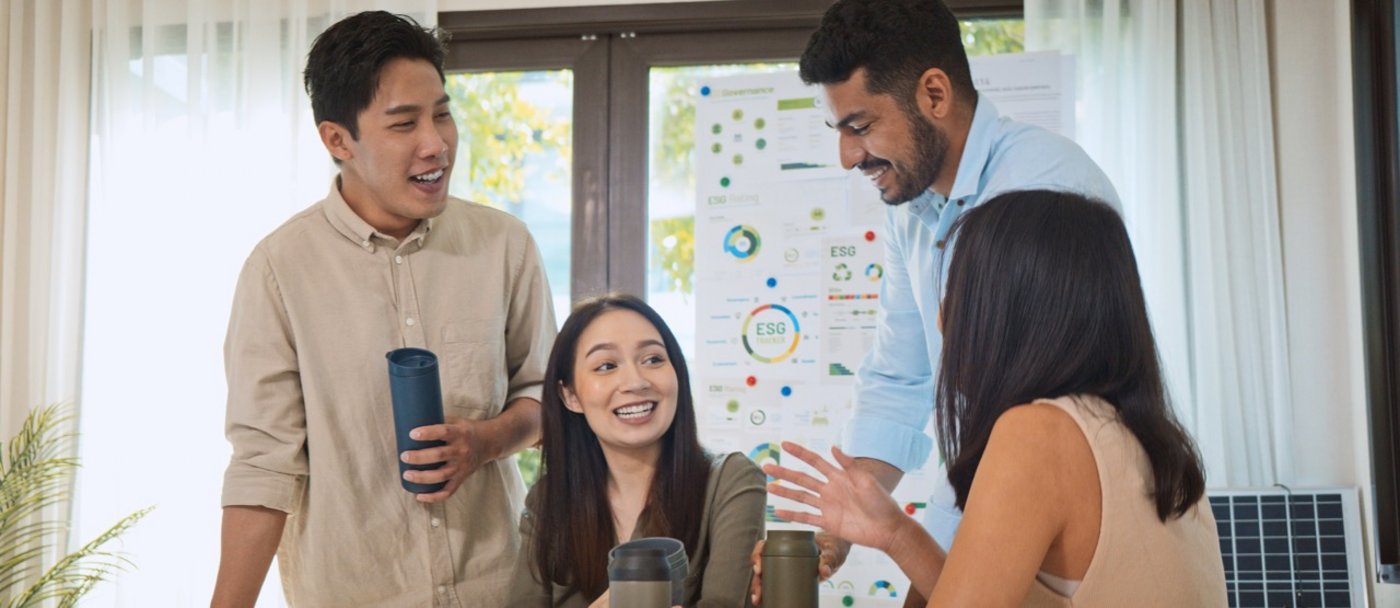 Vier Personen diskutieren ihre Ideen vor einem Plakat mit Umweltstatistiken. Foto: Urbanscape - stock.adobe.com